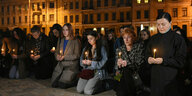 Frauen in Kiew knien mit Kerzen in der Hand zum Gedenken an getötete Soldaten
