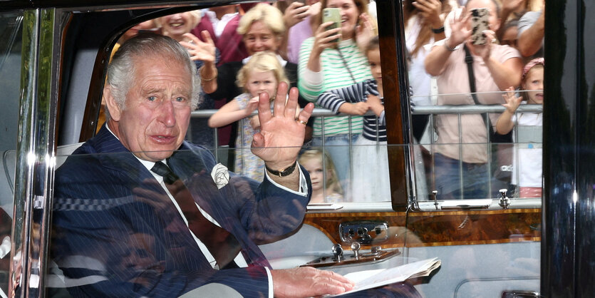 König Charles III. winkt aus einem Auto