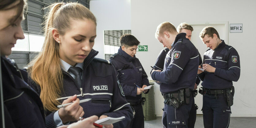 Junge Polizist:innen mit Notizen