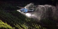Hubschrauber versprüht Pflanzenschutzmittel im Weinberg