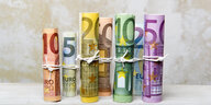Eingerollte und verschnürte Euroscheine in einer Reihe