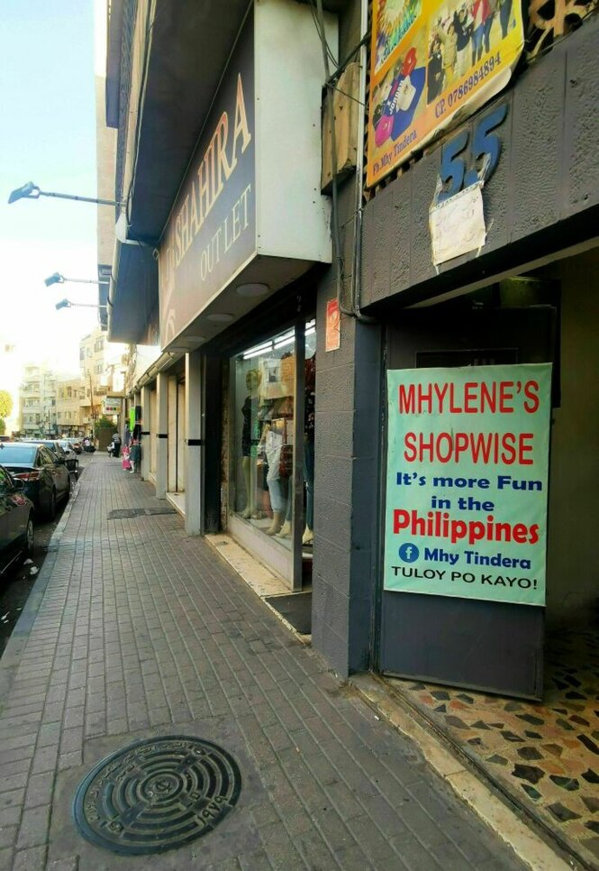 An einer Hausfassade wirbt ein Schild um philippinische Kundinnen