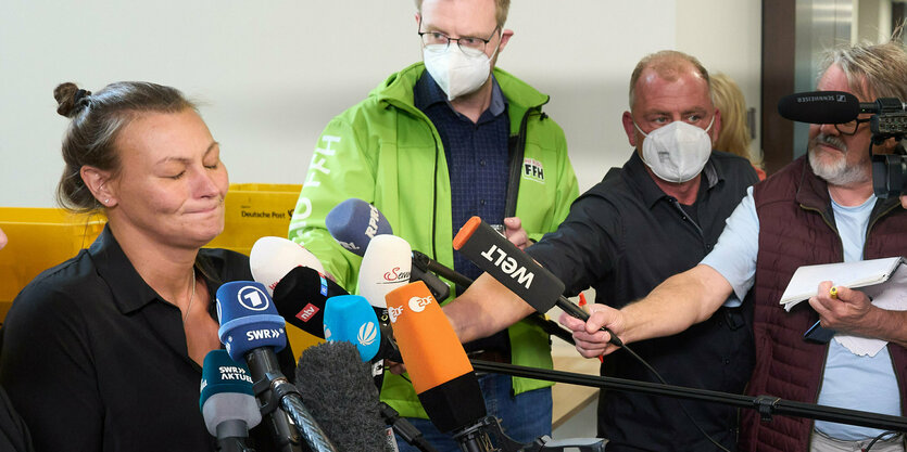 Eine Frau mit geschlossenen Augen, vor ihr Mikrofone