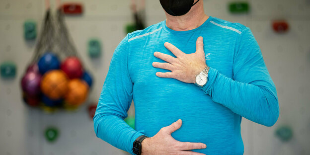 Ein Mann mit Schutzmaske macht Atemübungen
