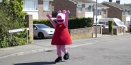 Peppa Pig Figur spaziert in einer Vorstadt