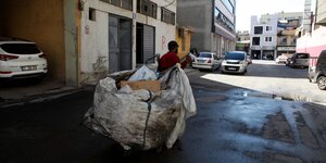 Ein Mann läuft mit einem Karren voller Müll dorch die Straßen von Gaziantep in der Türkei