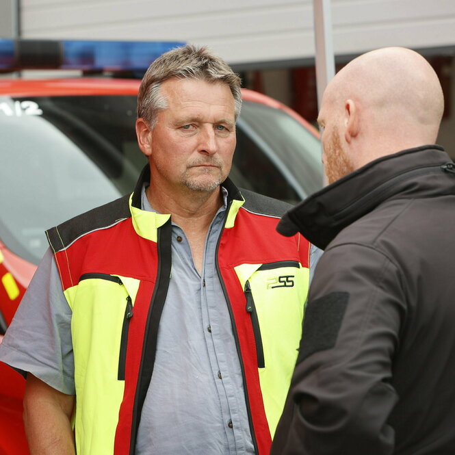 Roland Pietsch in Warnweste vor einem Einsatzwagen.