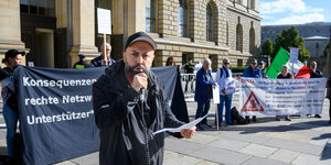 Koçak hält ein Mikrofon auf einer Kundgebung vor dem Berliner Abgeordnetenhaus