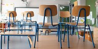 Stühle in einem Klassenzimmer stehen auf Tischen