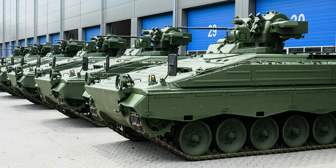 Marder-Schützenpanzer stehen vor einer Halle mit blauen Toren