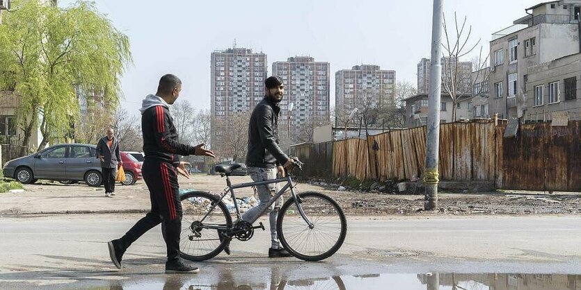 Zwie Männer schieben ein Fahrrad