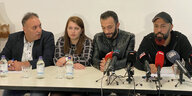 An einem Tisch sitzen vier Personen mit Mikrofonen, in der Mitte das syrische Ehepaar