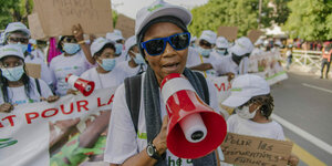 Senegal: Eine Frau mit Megafon läuft einer Demonstration voran