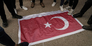 Füße, die in einem Kreis um die türkische Flagge herum stehen