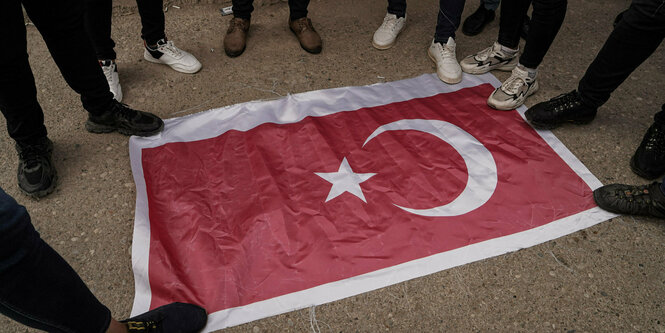 Füße, die in einem Kreis um die türkische Flagge herum stehen