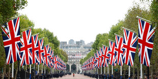 Blick auf eine breite Allee, zu beiden Seiten unzählige gesenkte Union Jacks