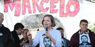 Menschen tragen T-shirts mit dem Konterfei des getöteten Politikers Marcelo Arruda, im Vordergrund spricht PT-Chefin Gleisi Hoffmann in ein Mikrofon