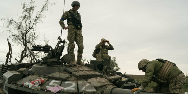 Drei Soldaten auf einem Panzer