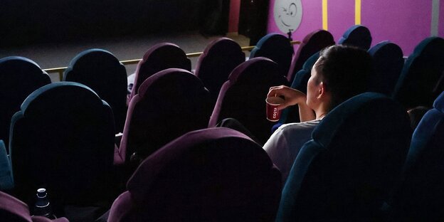 Eine einzelne Zuschauerin in einem Kinosaal
