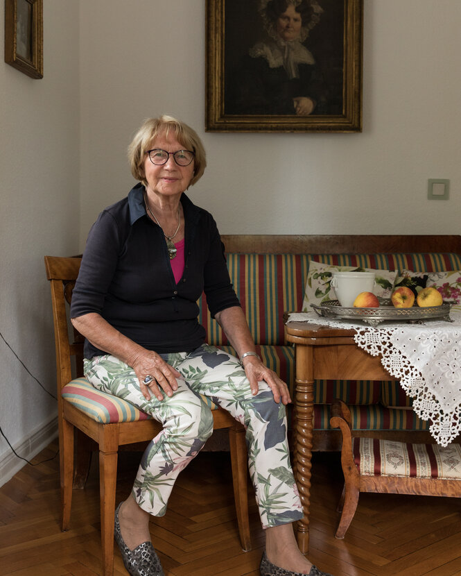 Eine Frau sitzt auf einem Stuhl in einer Biedermeier-Sitzecke