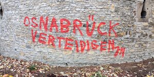 Auf einer Steinmauer steht in roter Schrift gesprüht: "Osnabrück verteidigen JN"