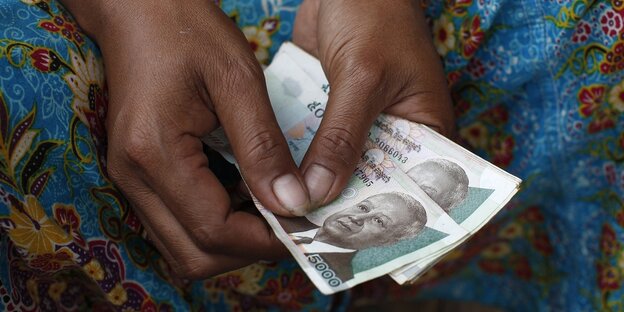 Eine Hand hält Kambodschanische Banknoten