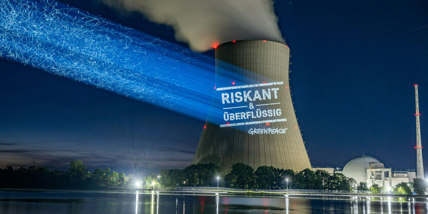 Leuchtschrift "riskant und überflüssig" auf qualmendem Kühlturm