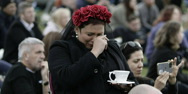 Eine Frau weint und hält eine Teetasse in den Händen
