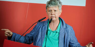 Berlins Linkenschefin Katina Schubert vor einer roten Wand mit Parteiaufschrift