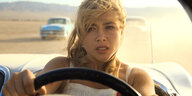Alice (Florence Pugh) rast in einem Cabriolet, von anderen Autos verfolgt, durch die Wüste.
