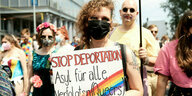 Jemand trägt ein Schild mit der Aufschriuft "Stop Deportation - Asyl für alle verfolgten Queers"