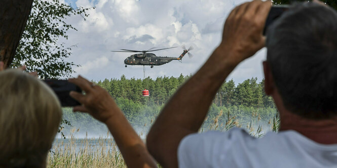 Ein Bundeswehrhubschrauber vom Typ Bell CH-53 holt Löschwasser zur Waldbrandbekämpfung aus dem Kiebitzer Baggerteich