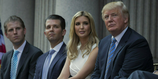 Donald Trump sitzt neben drei seiner Kinder