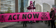 "Act now" steht auf einem Transparent der Umweltschutzgruppe "extinction rebellion" bei einer Straßenblockade am Potsdamer Platz in Berlin
