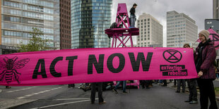 "Act now" steht auf einem Transparent der Umweltschutzgruppe "extinction rebellion" bei einer Straßenblockade am Potsdamer Platz in Berlin