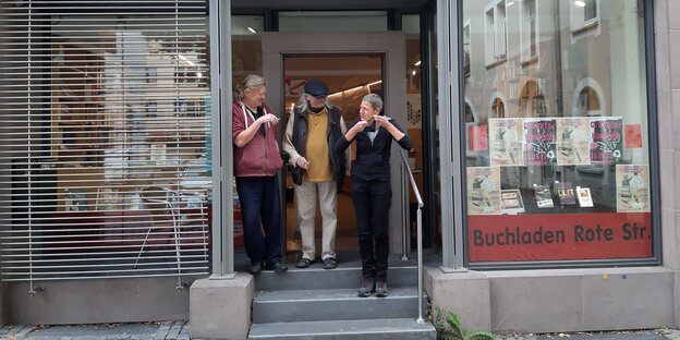 Vor dem Schaufenster des Göttinger Buchladens Rote Straße stehen drei Menschen: Jürgen Ehbrecht, Mitglied im Kollektiv, Klaus Schild und Mechthild Röttering , die beiden GeschäftsfüherInnen