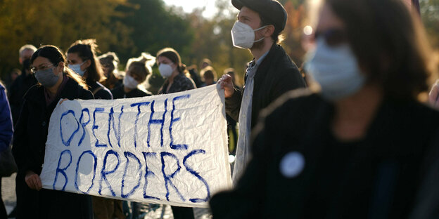 Demonstarnten halten ein Banner mit der Aufschrift "Open the Borders!"