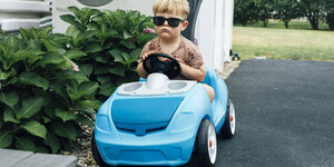Ein Kind fährt in einem Spielzeugauto