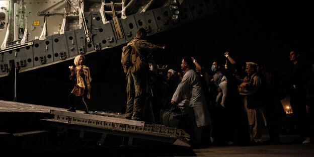 People board a military aircraft