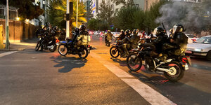 Mehrere schwarz gekleidete Männer auf Motorrädern in einer Straße