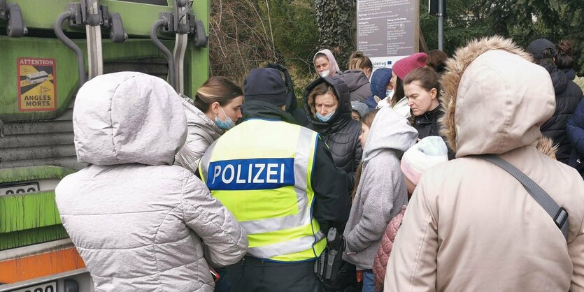 Ein Polizist umringt von Menschen