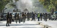 Taliban-Kämpfer stehen am Explosionsort in der Nähe einer Moschee