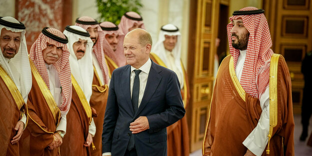 Bundeskanzler Olaf Scholz (M, SPD) wird vom Kronprinzen des Königreichs Saudi-Arabien Mohammed bin Salman al-Saud (r) und einer Delegation im Al-Salam-Palast empfangen
