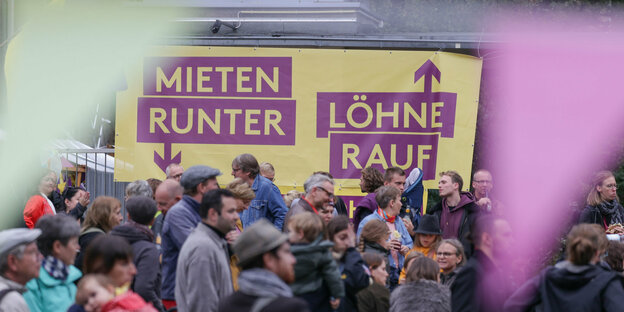 Menschen beim Fest von Deutsche Wohnen und Co enteignen vor einem Plakat der INitiative