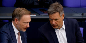 Christian Lindner und Robert Habeck sitzen nebeneinander im Plenum des Deutschen Bundestages und unterhalten sich