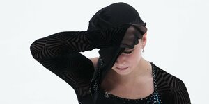 Eiskünstläuferin Kamila Walijewa verbirgt ihr Gesicht unter einer Kapuze