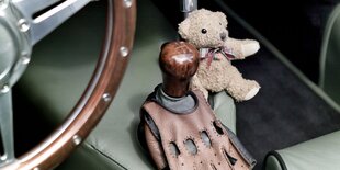 Ein Armaturenbrett im Oldtimer mit Schaltung und einem Kuscheltier