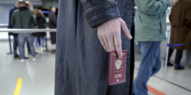 Ein Mann hält an einer Passkontrolle seinen Ausweis in der Hand
