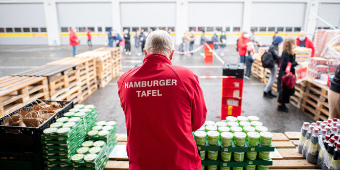 Ein Tafel-Mitarbeiter steht vor einer Ausgabestelle