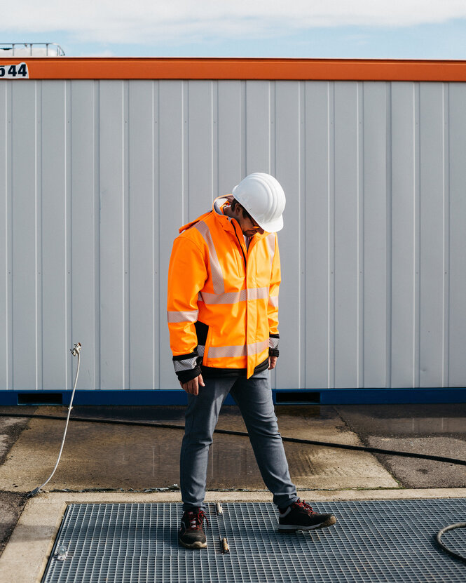 René Tilsen steht auf dem Borhloch der Wärmepumpe